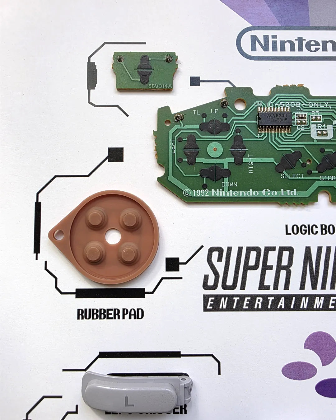 Shadowbox SNES detalle 2: vista cercana de los seis botones, joystick y placa del control SNES desarmado