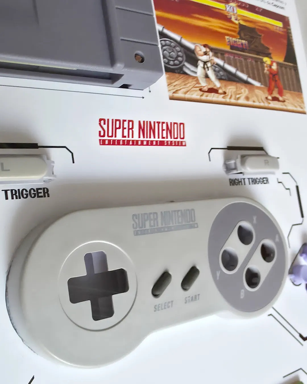 Shadowbox Control SNES + Street Fighter II detalle 2: vista cercana del cartucho Street Fighter II y placa del control